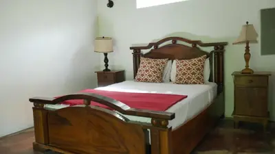 a bedroom with a wooden bed and two night stands at Villa Quebrada Estate in Montezuma