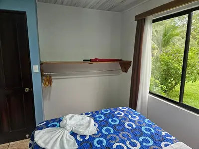 a bedroom with a bed and a window at Full equipado, WiFi, AC, vista volcán, 1er piso in Fortuna
