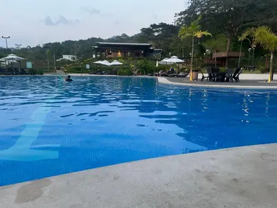 a large swimming pool with blue water at Namú Apartment in Herradura