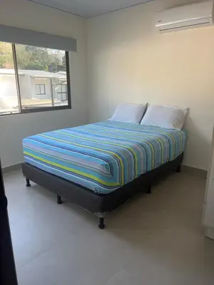 a bed sitting in a room with a window at Namú Apartment in Herradura