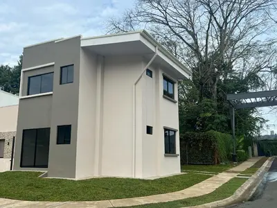 a white house with a large window at Namú Apartment in Herradura