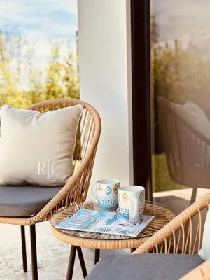 a wicker chair with two cups on a table with a pillow at Casa Morfa in Uvita