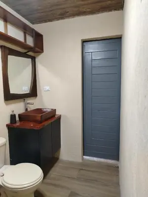 a bathroom with a toilet and a blue door at Apartamento Roble Sabana in Tapantí