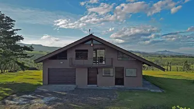 a house with a balcony on top of a field at Casa Vacacional floreva in Tapantí