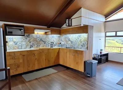 a kitchen with wooden cabinets and a wall with tiles at Casa Vacacional floreva in Tapantí