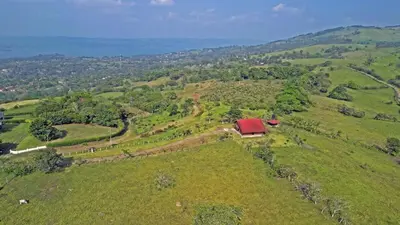 an aerial view of a farm on a hill with a red roof at Casa Vacacional floreva in Tapantí