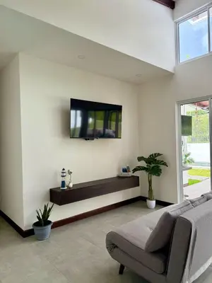 a living room with a couch and a tv on a wall at Casa kai in Agujas