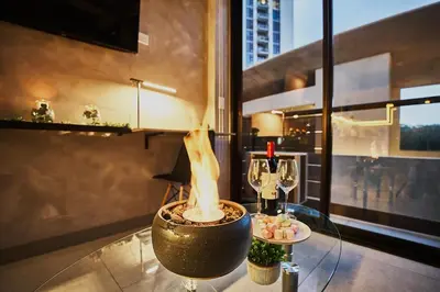 a living room with a fireplace on a glass table at Unique Industrial Apt Near Airport in La Sabana in San José