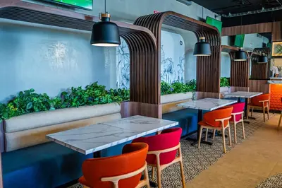 a restaurant with two tables and chairs and plants at Unique Industrial Apt Near Airport in La Sabana in San José