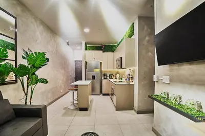 a kitchen and living room with a couch and a table at Unique Industrial Apt Near Airport in La Sabana in San José