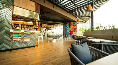 a restaurant with a bar and tables and chairs at Unique Industrial Apt Near Airport in La Sabana in San José