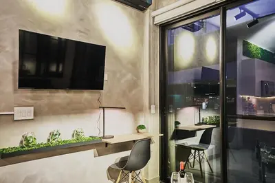 a living room with a tv on a wall at Unique Industrial Apt Near Airport in La Sabana in San José