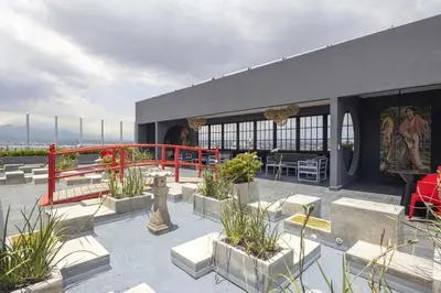 a building with a patio with benches and plants at Unique Industrial Apt Near Airport in La Sabana in San José