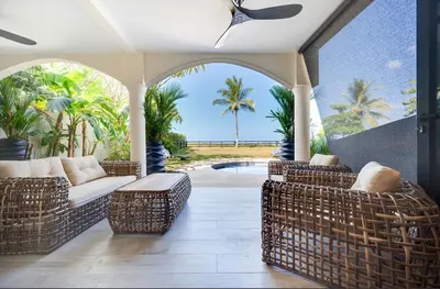 an outdoor patio with wicker furniture and a pool at Beachfront2 bed 2 bathPortreroFlamigo-Marina in Playa Flamingo