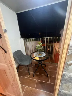 a small table and a chair on a balcony at BAyRA Homes in Alajuela City