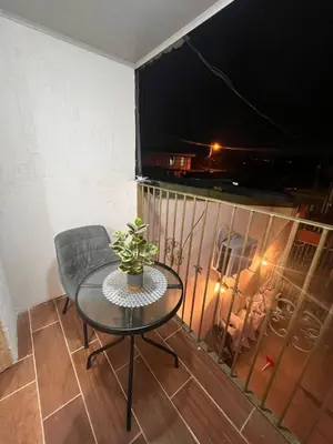 a table and a chair and a television on a balcony at BAyRA Homes in Alajuela City