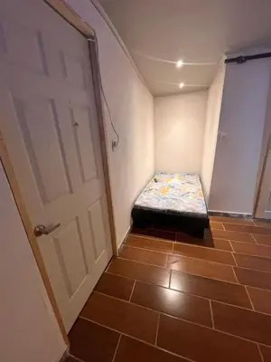 a small room with a bed next to a door at BAyRA Homes in Alajuela City