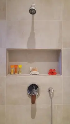 a shelf in a shower with a faucet at Condo Niko - Centrally Located, Steps to Beach! in Tamarindo