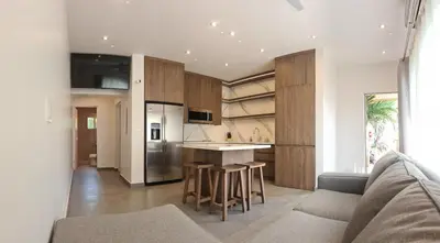 a kitchen with wooden cabinets and a kitchen island at Condo Popeye - Cute condo in the heart of Tama! in Tamarindo