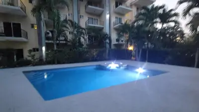 a swimming pool with lights in front of a building at Condo Popeye - Cute condo in the heart of Tama! in Tamarindo
