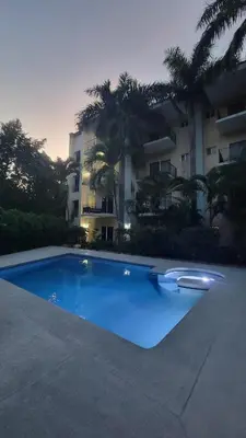 a large blue swimming pool in front of a building at Condo Popeye - Cute condo in the heart of Tama! in Tamarindo