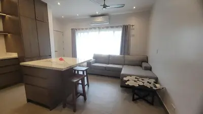 a kitchen and living room with a couch and a table at Condo Popeye - Cute condo in the heart of Tama! in Tamarindo