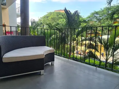 a balcony with a bench and a view of a garden at Condo Popeye - Cute condo in the heart of Tama! in Tamarindo