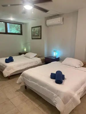 two beds in a room with blue towels on them at Apartment 4 personas, full equipado, Santa ana , San Jose Costa Rica in Isla Herradura