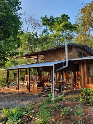 a large wooden house with a roof at Cabaña del Bosque in Tapantí