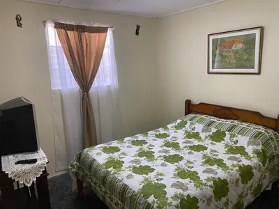 a bedroom with a bed and a television and a window at Close to Walmart supermarket chain in San Pablo