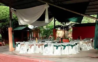 a group of tables with white chairs and a canopy at Hotel Maguey in Chilamate