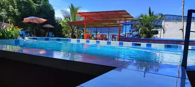 a large swimming pool with a red umbrella and a pavilion at Hotel Maguey in Chilamate