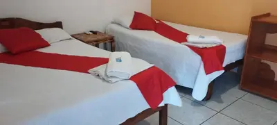 a room with two beds with red and white sheets at Hotel Maguey in Chilamate