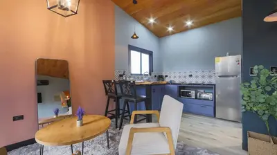 a kitchen with blue cabinets and a table and chairs at Refugio Turquesa-Luxury King Suite with Private Jacuzzi Balcony-5 min to La Fortuna in Fortuna