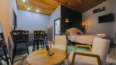 a bedroom with a bed and a table and chairs at Refugio Turquesa-Luxury King Suite with Private Jacuzzi Balcony-5 min to La Fortuna in Fortuna
