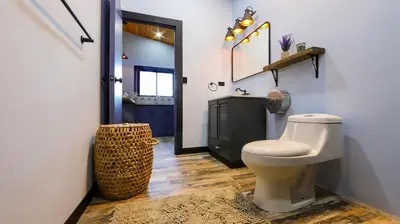 a bathroom with a white toilet and a black cabinet at Refugio Turquesa-Luxury King Suite with Private Jacuzzi Balcony-5 min to La Fortuna in Fortuna