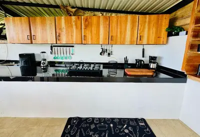 a kitchen with a black counter top and wooden cabinets at Kayala Dome - Private luxury Dome in La Ese