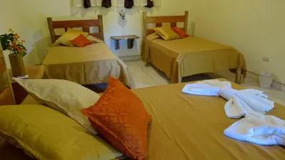 a room with three beds with towels on them at Hotel Cerro Lodge in Tarcoles