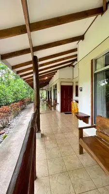 a porch of a house with a wooden ceiling at Hotel Cerro Lodge in Tarcoles