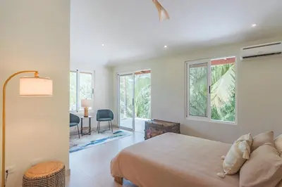 a bedroom with a bed and a desk with a chair at Eco-Luxurious Villa 4bdr - 5 min to the Beach in Uvita