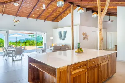 an open kitchen with a large island in a villa at Eco-Luxurious Villa 4bdr - 5 min to the Beach in Uvita