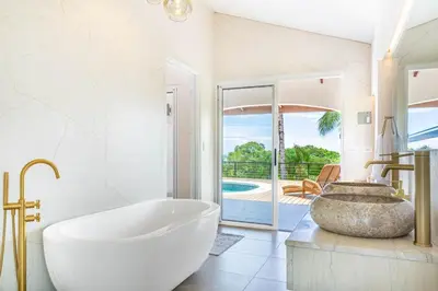 a bathroom with a tub and a view of a pool at Eco-Luxurious Villa 4bdr - 5 min to the Beach in Uvita