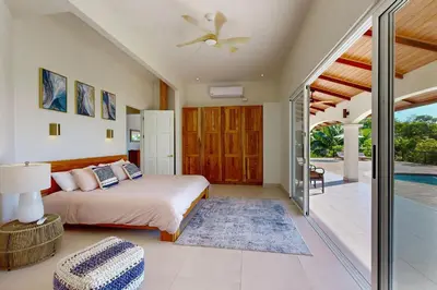 a bedroom with a bed and a ceiling fan at Eco-Luxurious Villa 4bdr - 5 min to the Beach in Uvita