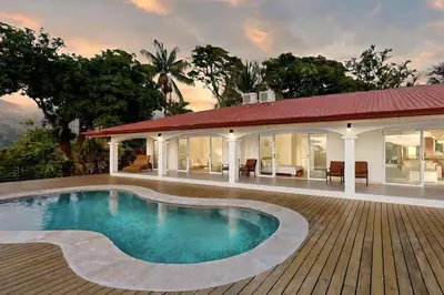 a swimming pool in front of a house at Eco-Luxurious Villa 4bdr - 5 min to the Beach in Uvita