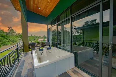 a large bathroom with two sinks and a balcony at Paraiso Lima -Luxury King Suite with Private Jacuzzi Balcony-5 min to La Fortuna in Fortuna