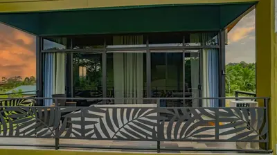 a screened in porch of a house with a green awning at Paraiso Lima -Luxury King Suite with Private Jacuzzi Balcony-5 min to La Fortuna in Fortuna