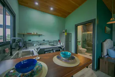 a kitchen with a sink and a table with bowls on it at Paraiso Lima -Luxury King Suite with Private Jacuzzi Balcony-5 min to La Fortuna in Fortuna