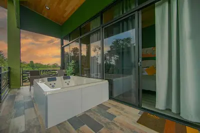 a large bathroom with a tub and a large window at Refugio Verdanza-Luxury King Suite with Private Jacuzzi Balcony-5 min to La Fortuna in Fortuna