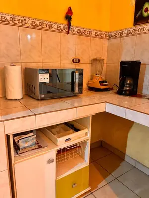 a microwave sitting on top of a kitchen counter at El Descanso in Jacó
