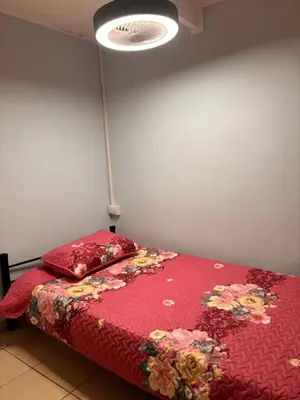 a bedroom with a bed with a red comforter and a lamp at El Descanso in Jacó